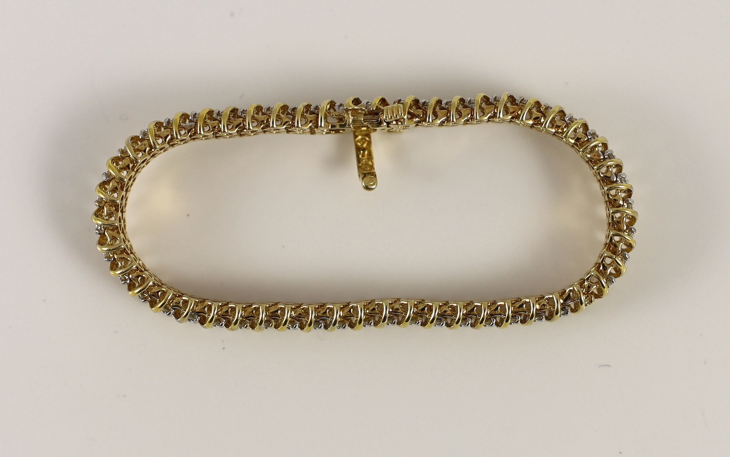 A modern 14k gold and twin row diamond set line bracelet